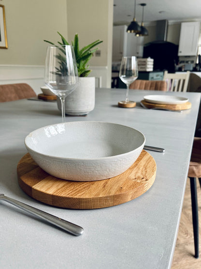 round oak dining set with a pottery bowl on a micro cement dining table